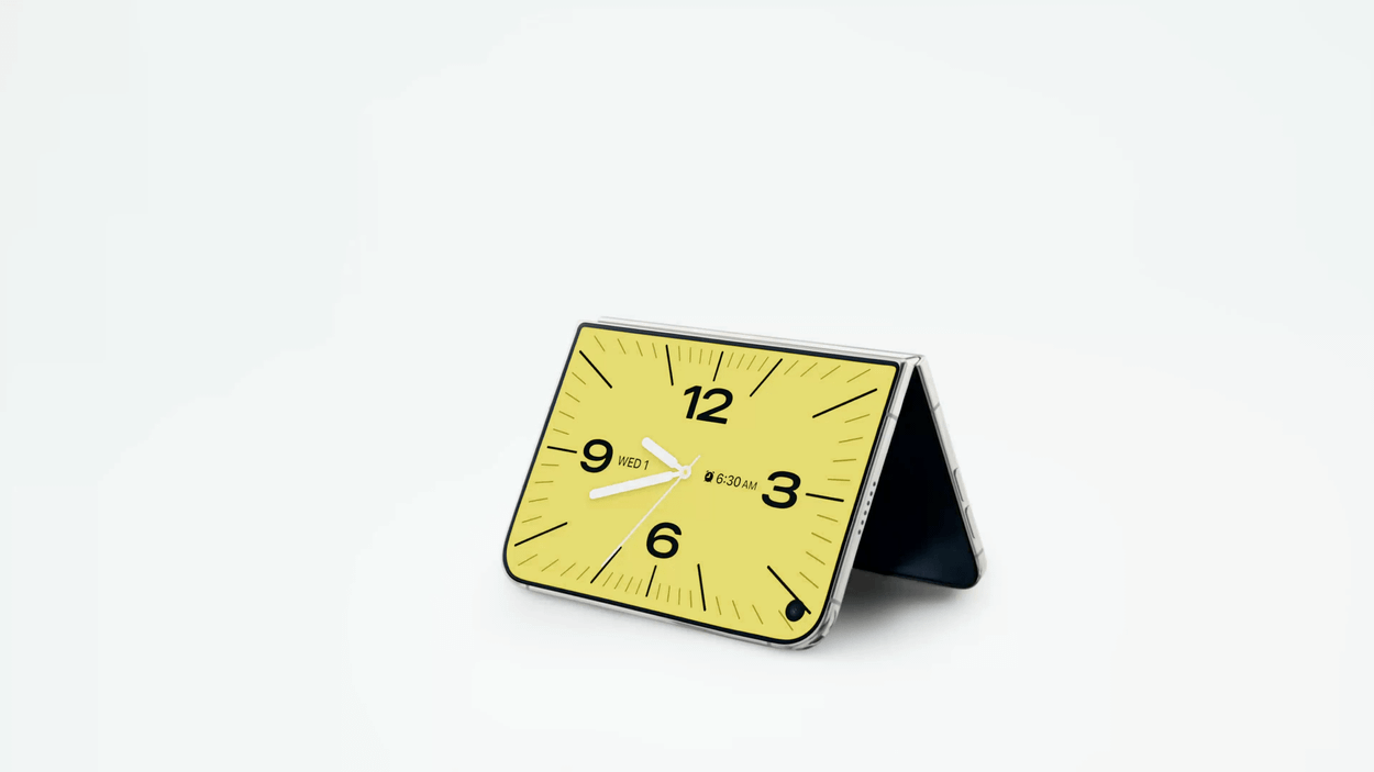 A foldable smartphone resting in a stand position displaying an analog clock face.