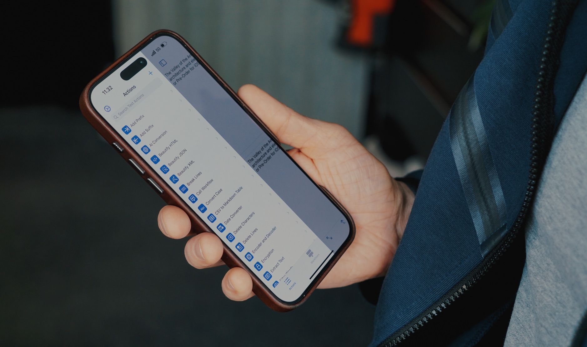 Eine Person hält ein Smartphone in der Hand, auf dem eine App mit verschiedenen Aktionen und Funktionen angezeigt wird. Das Gerät scheint ein iPhone zu sein, das in einer braunen Hülle steckt. Die Benutzeroberfläche zeigt Tools wie „Beautify JSON“ und „Convert Case“, die vermutlich zur Text- oder Datenbearbeitung dienen.