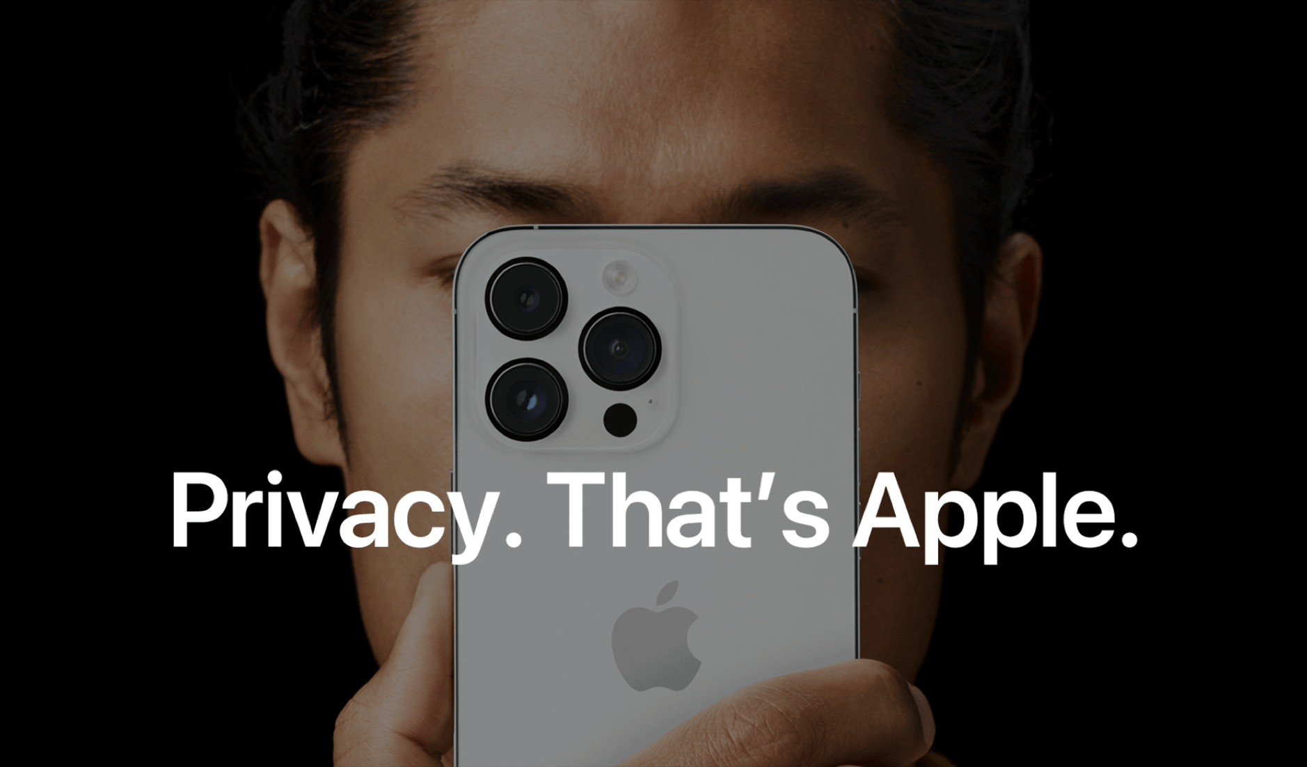 Auf dem Bild hält eine Person ein iPhone vor ihr Gesicht, sodass nur die Augen sichtbar sind. Im Vordergrund steht der weiße Text: "Privacy. That's Apple." Das Bild vermittelt den Fokus von Apple auf Datenschutz und Privatsphäre.