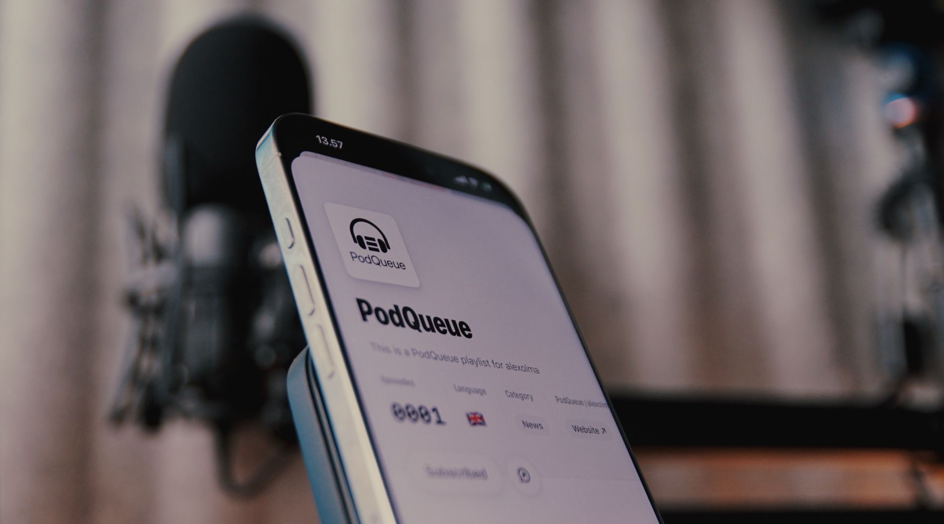 This image shows a close-up of a smartphone displaying the "PodQueue" app. The interface indicates it is a playlist for "alexaoma," featuring details like the number of episodes, language, category, and website link. In the background, you can see a microphone, suggesting a podcasting context.