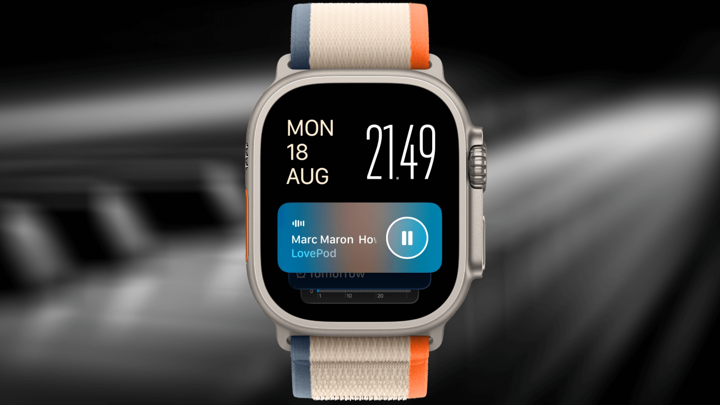 Silver Apple Watch Ultra displaying the time (21:49), date (Monday, August 18), and a paused podcast episode of "Marc Maron How," with a beige and colorful sport loop band against a dark, blurred background.
