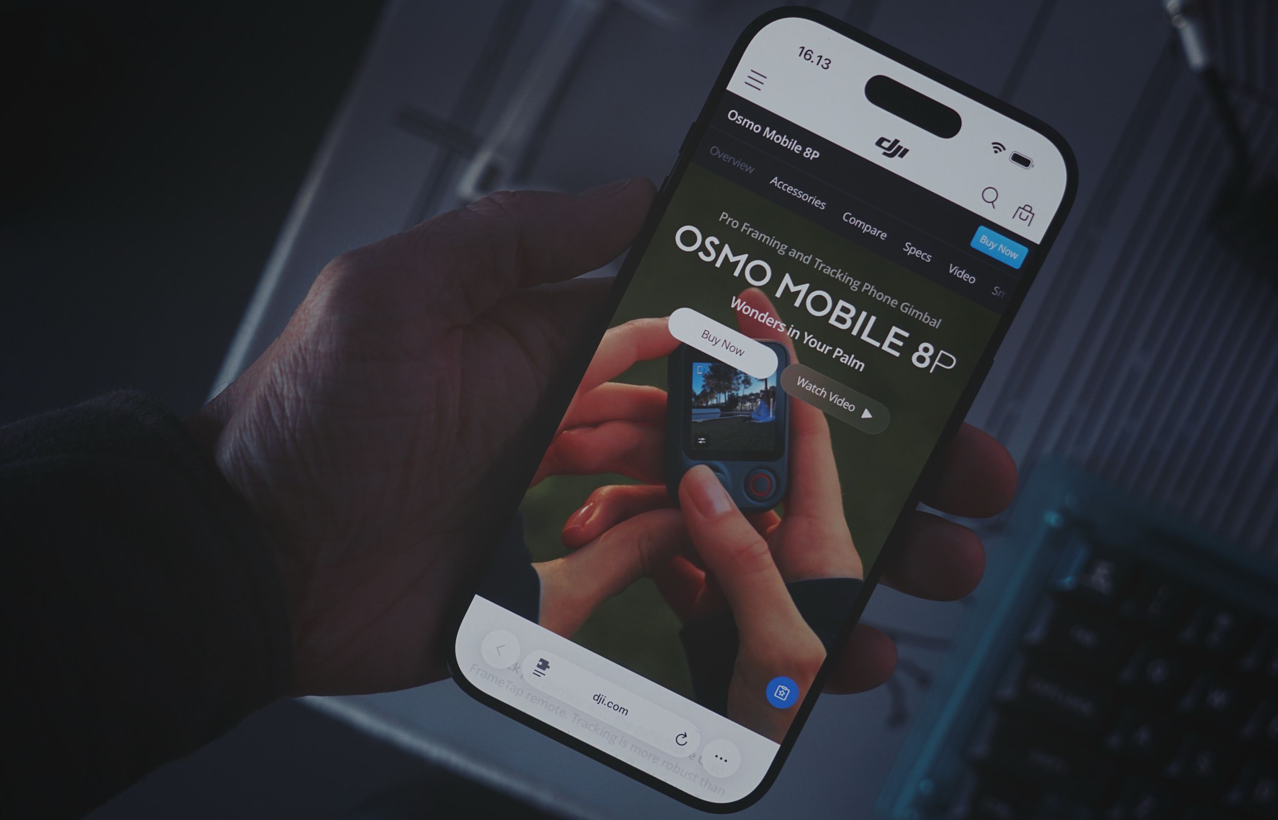 Eine Hand hält ein Smartphone, das die DJI-Produktseite für den Osmo Mobile 8P Gimbal anzeigt. Auf dem Bildschirm sind Produktinformationen zu sehen, darunter der Text: "16.13", "Osmo Mobile 8P", "Overview Accessories Compare Specs Video", "Buy Now", "Pro Framing and Tracking Phone Gimbal", "OSMO MOBILE 8P", "Wonders in Your Palm", "Buy Now", "Watch Video", "dji.com" und "Tap remote: Tracking is more robust than...".