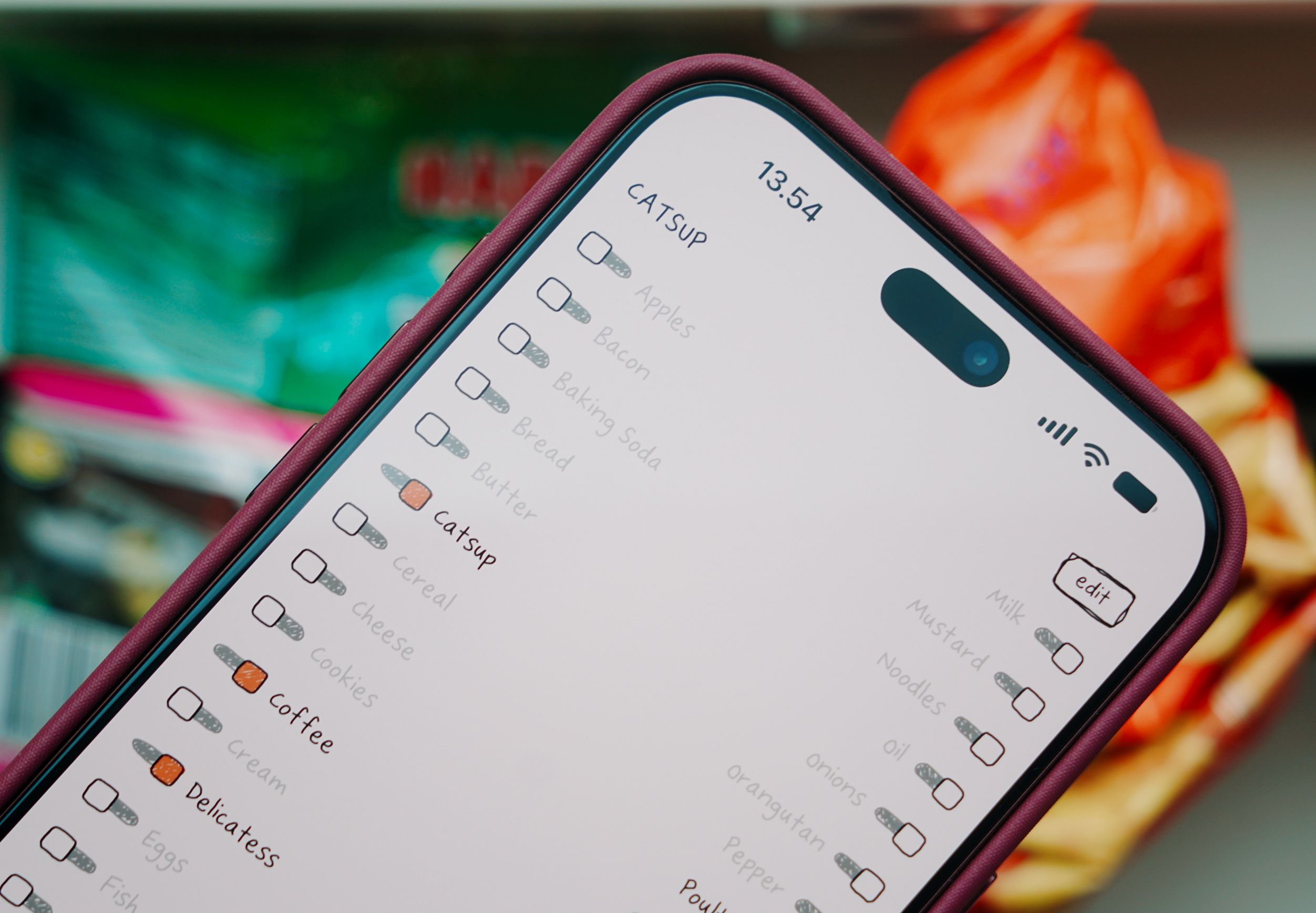 A smartphone screen displaying a grocery checklist application with items like catsup and apples.