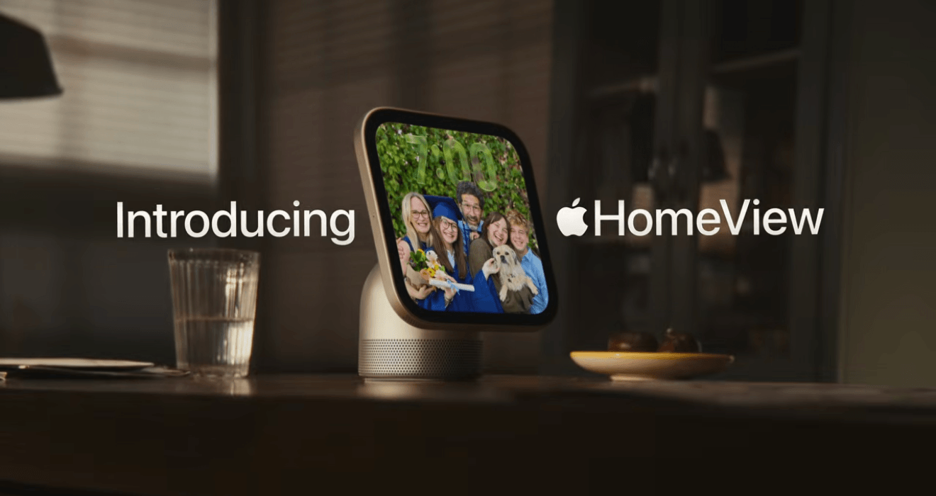 A smart home device with a screen showing a family photo, placed on a wooden table with a glass of water and a plate with two apples nearby. The text 'Introducing Apple HomeView' appears beside the device.