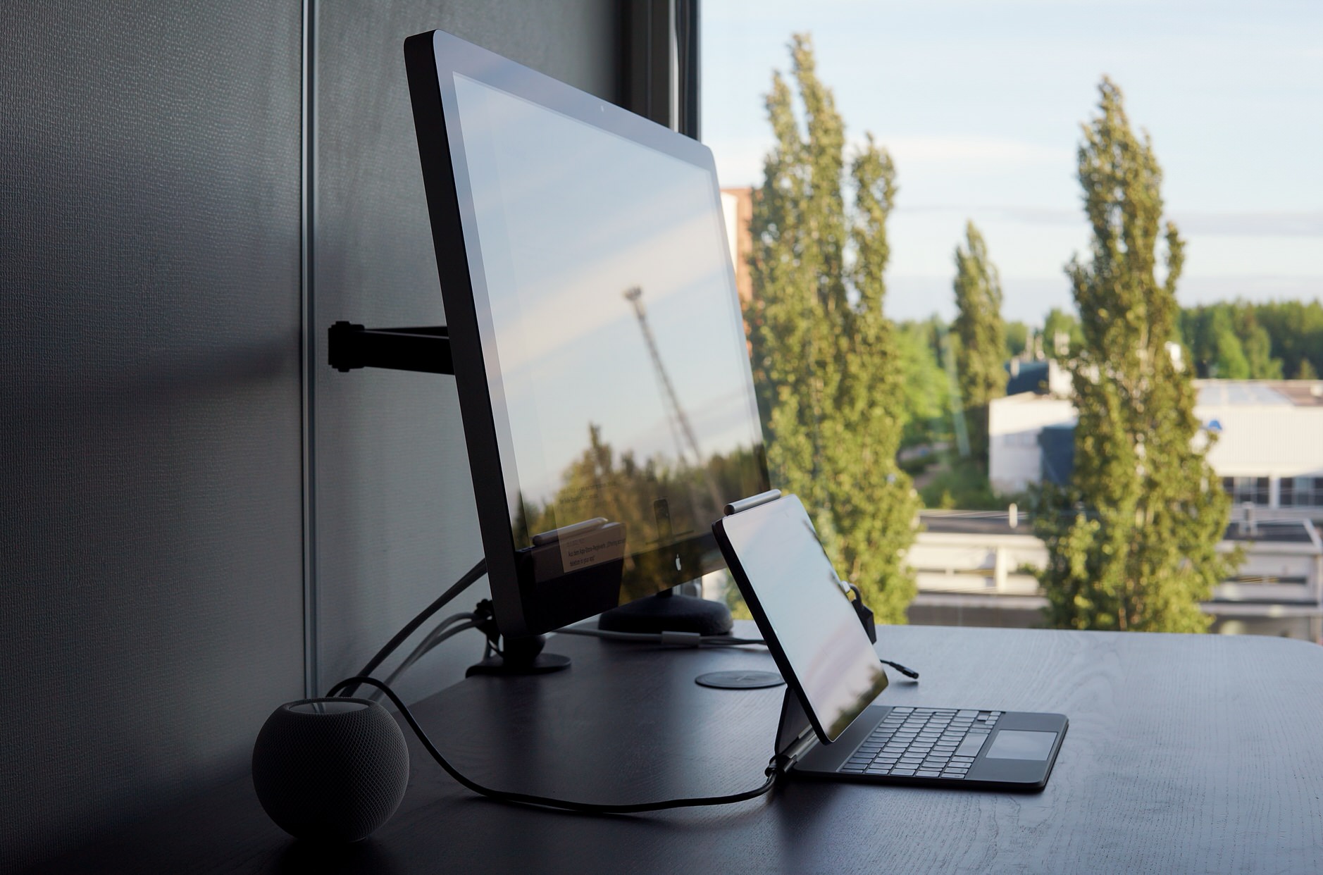 Bild zeigt Schreibtisch mit LED Cinema Display, HomePod mini und iPad Air im Magic Keyboard.