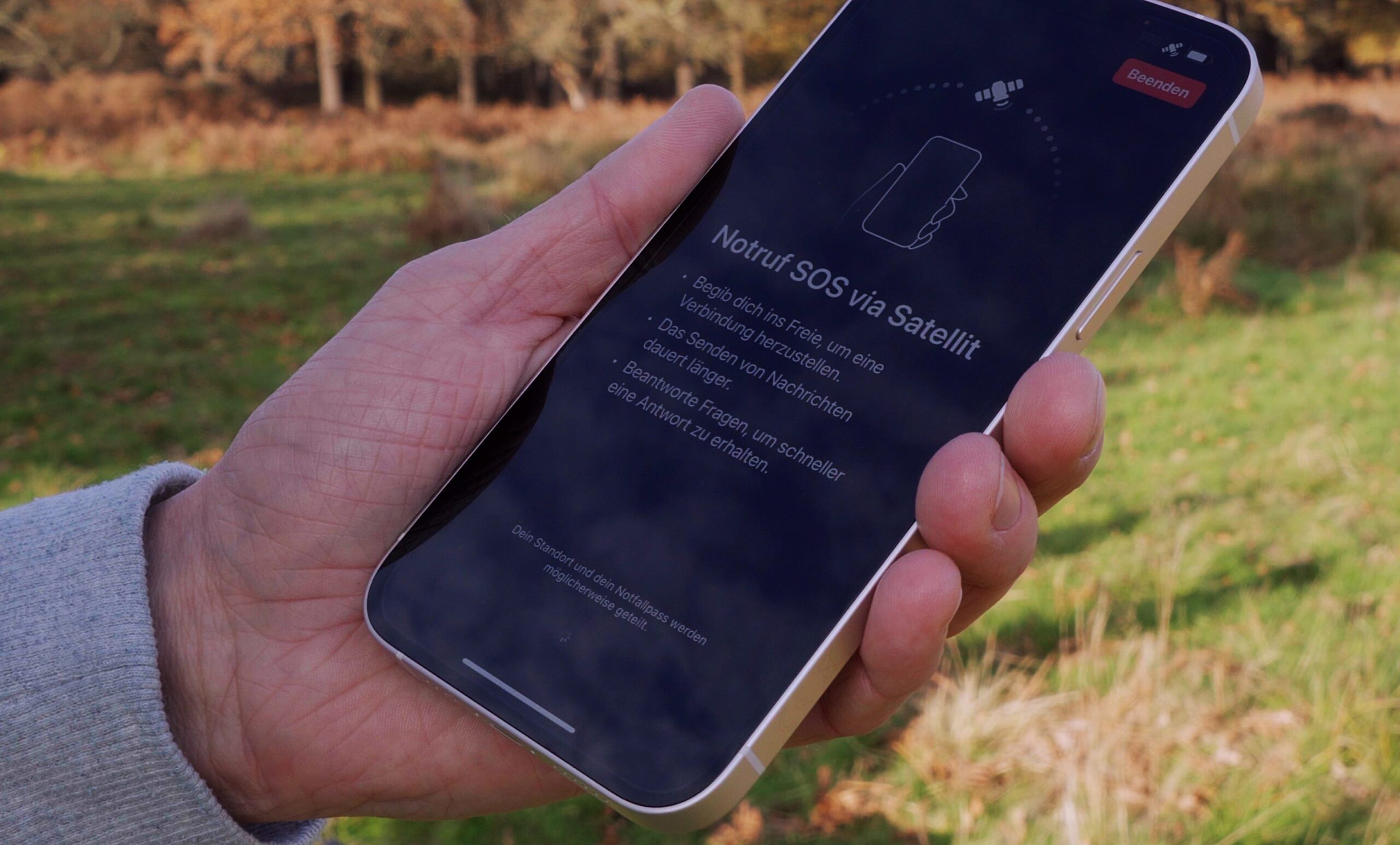 Bild zeigt iPhone mit Erklärbildschirm von Notruf SOS via Satellit.