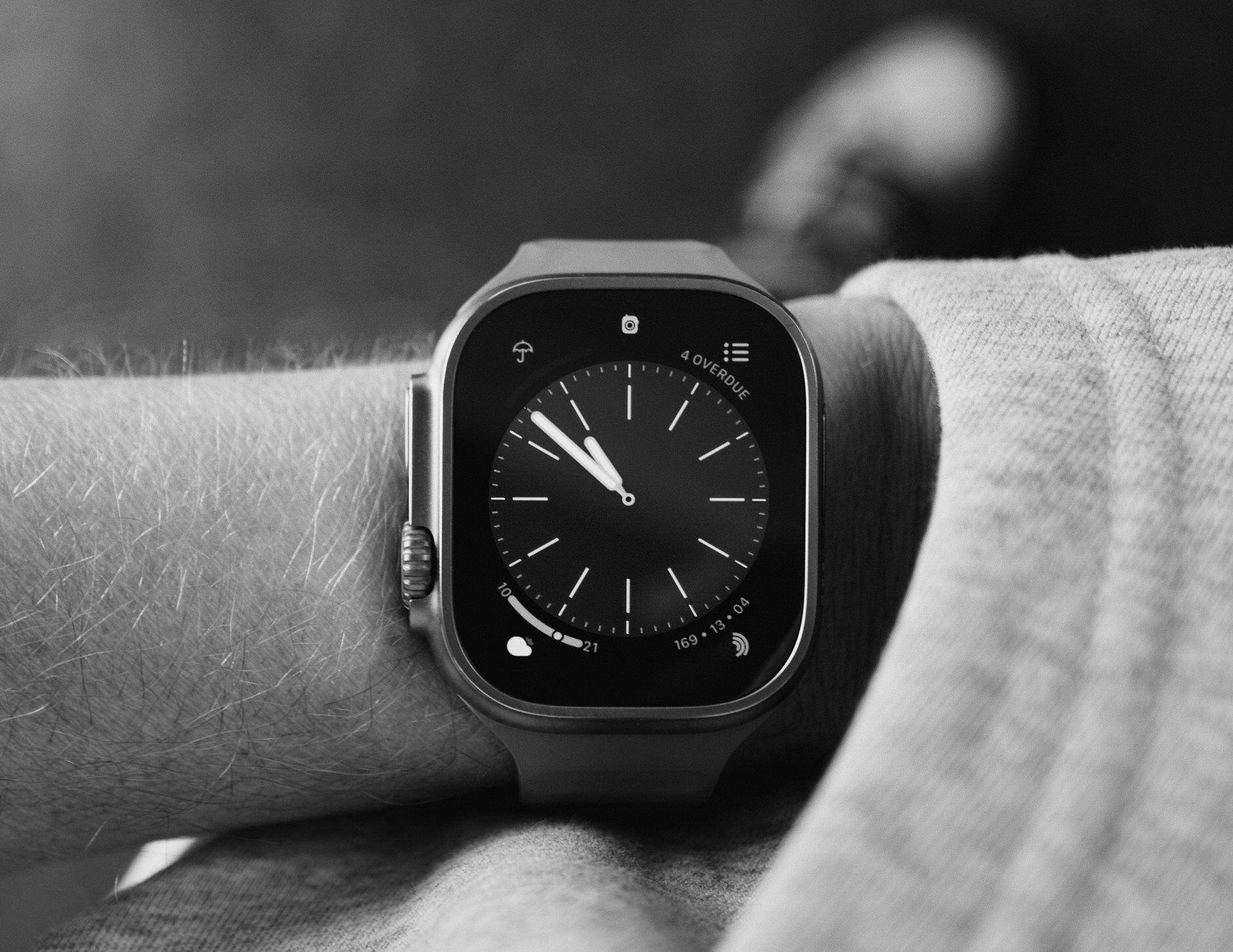 Apple Watch in schwarz/weiß an Handgelenk.