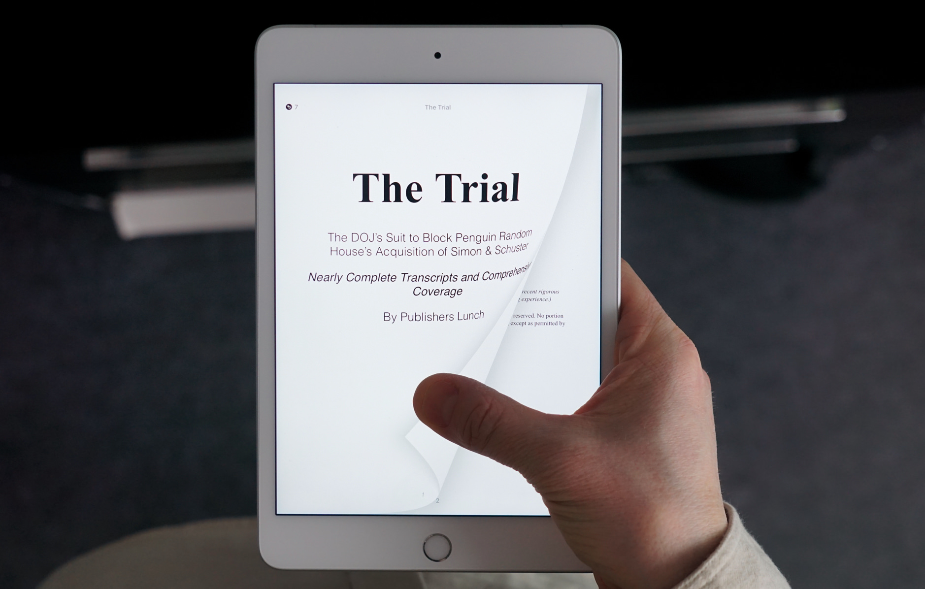 iPad mini in Hand zeigt Buch-Cover von „The Trail“. 