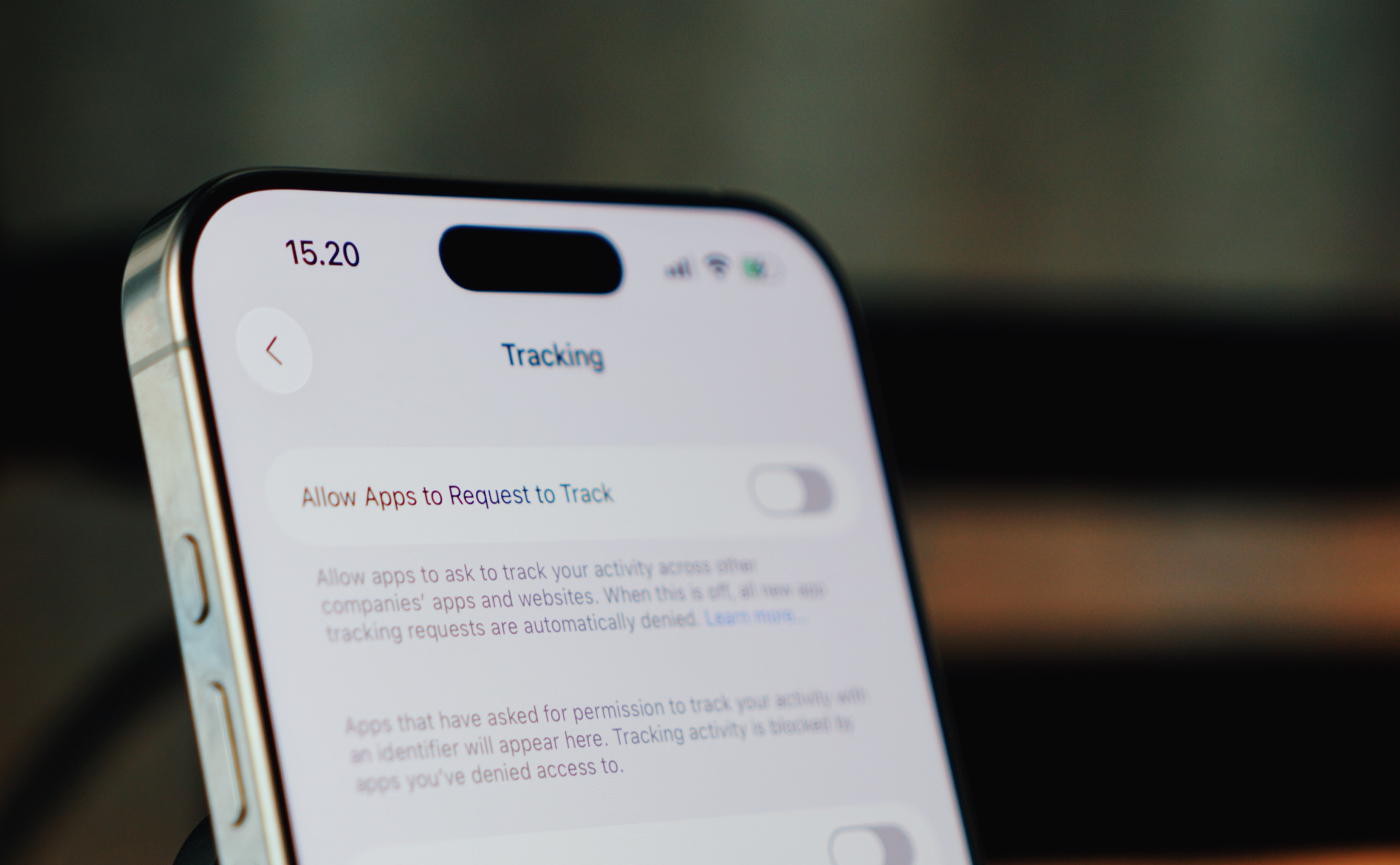 Close-up of a smartphone screen displaying privacy settings, with "Tracking" header, "Allow Apps to Request to Track" toggle, and explanatory text about app tracking. The time is displayed as 15.20 at the top left.
