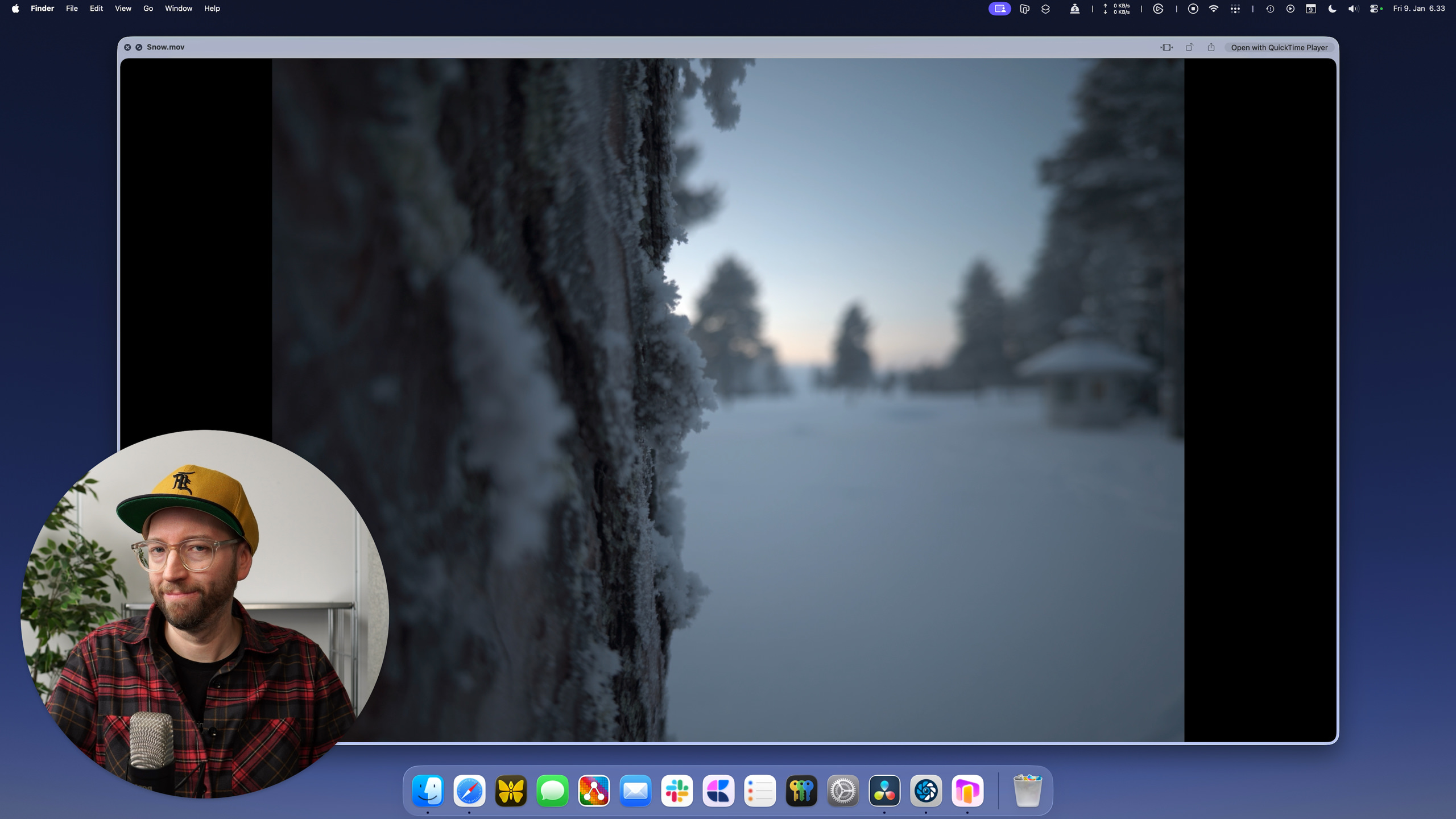 Mit Frost bedeckte Baumrinde im Vordergrund einer Winterlandschaft, durch ein QuickTime Player-Fenster auf einem Mac-Desktop betrachtet, mit einem Mann in der Ecke.