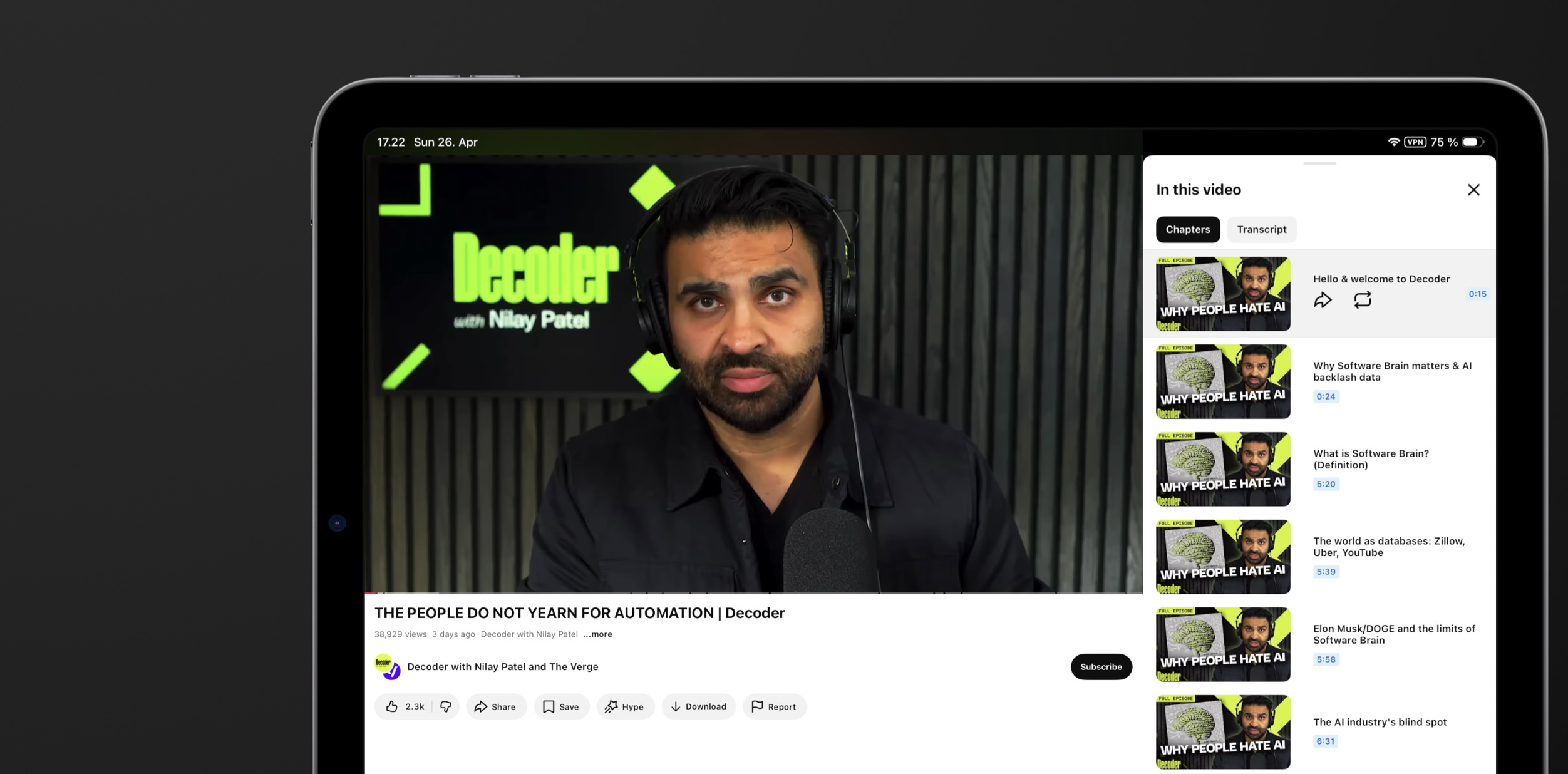 Ein Tablet-Bildschirm zeigt ein YouTube-Video eines bärtigen Mannes, der in einem Studio in ein Mikrofon spricht. Im Hintergrund befindet sich ein Logo mit der Aufschrift „Decoder“. Auf der rechten Seite ist eine Kapitelübersicht zu sehen. Der angezeigte Text lautet: „THE PEOPLE DO NOT YEARN FOR AUTOMATION | Decoder“.