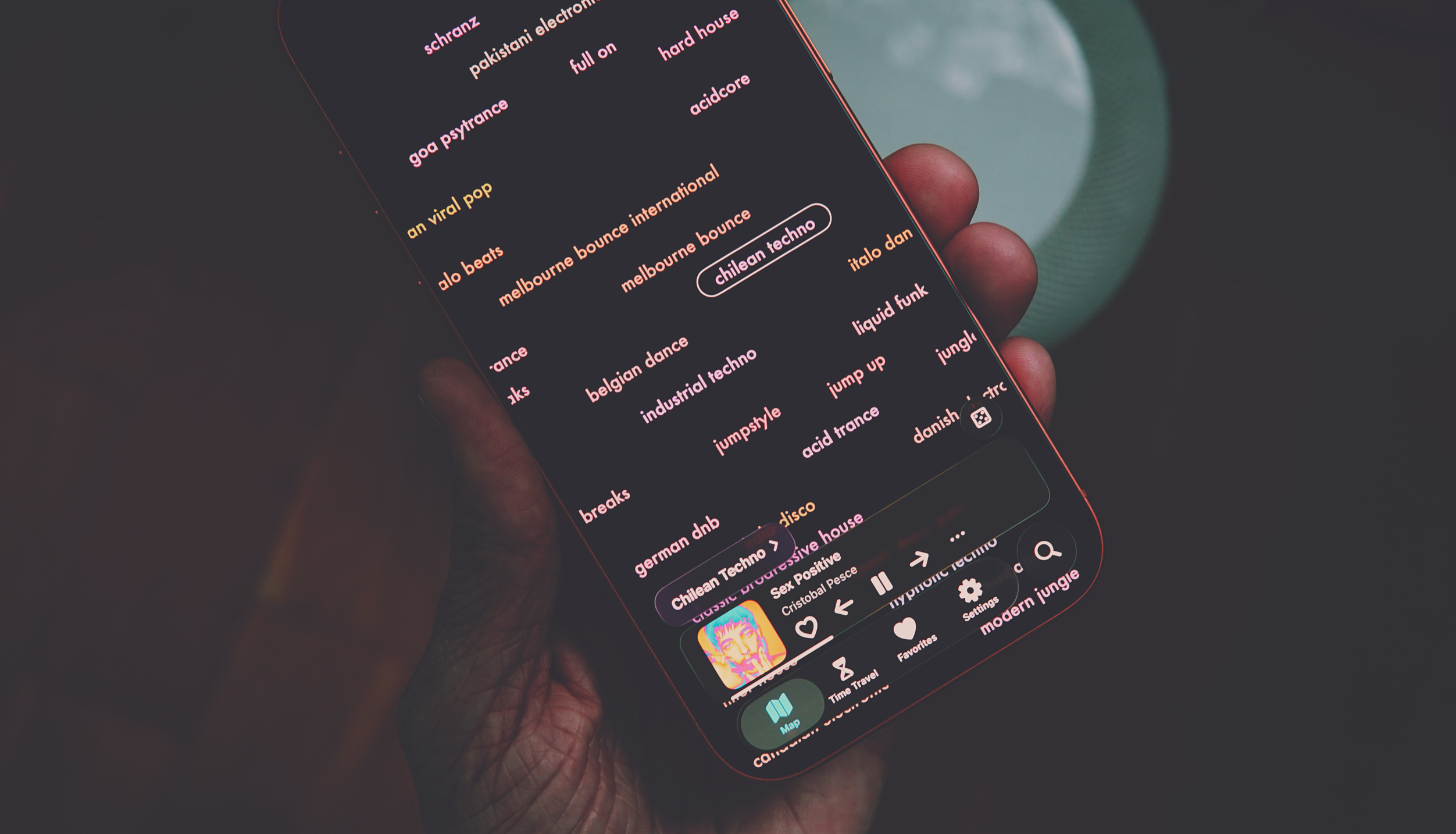 Die Hand einer Person hält ein Smartphone, das eine Musik-Discovery-App im Dunkelmodus zeigt. Auf dem Bildschirm befinden sich zahlreiche Genre-Tags.