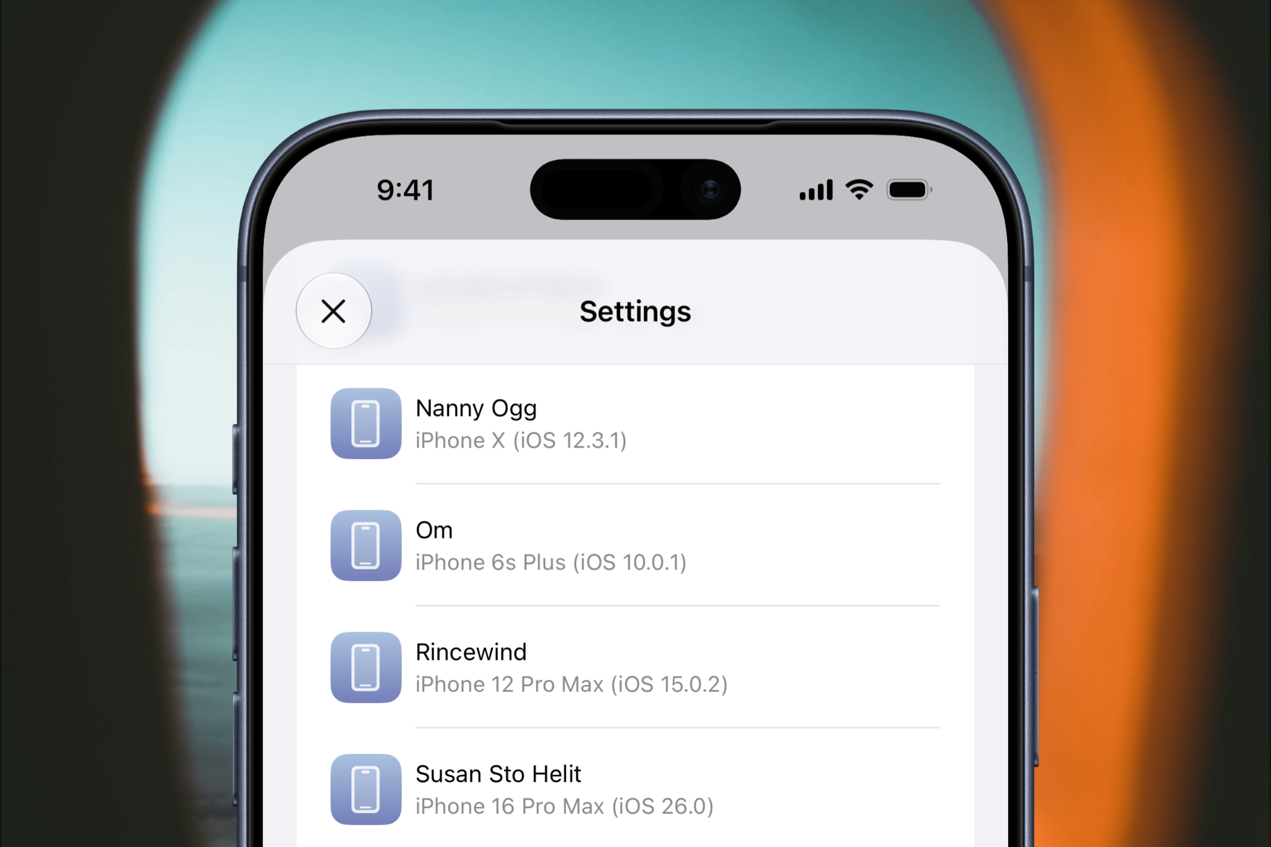 Ein Smartphone-Bildschirm zeigt das Einstellungsmenü zur Geräteverwaltung, in dem mehrere verbundene Apple-Geräte mit ihren Modellnamen und iOS-Versionen vor einem unscharfen Hintergrund aufgelistet sind.