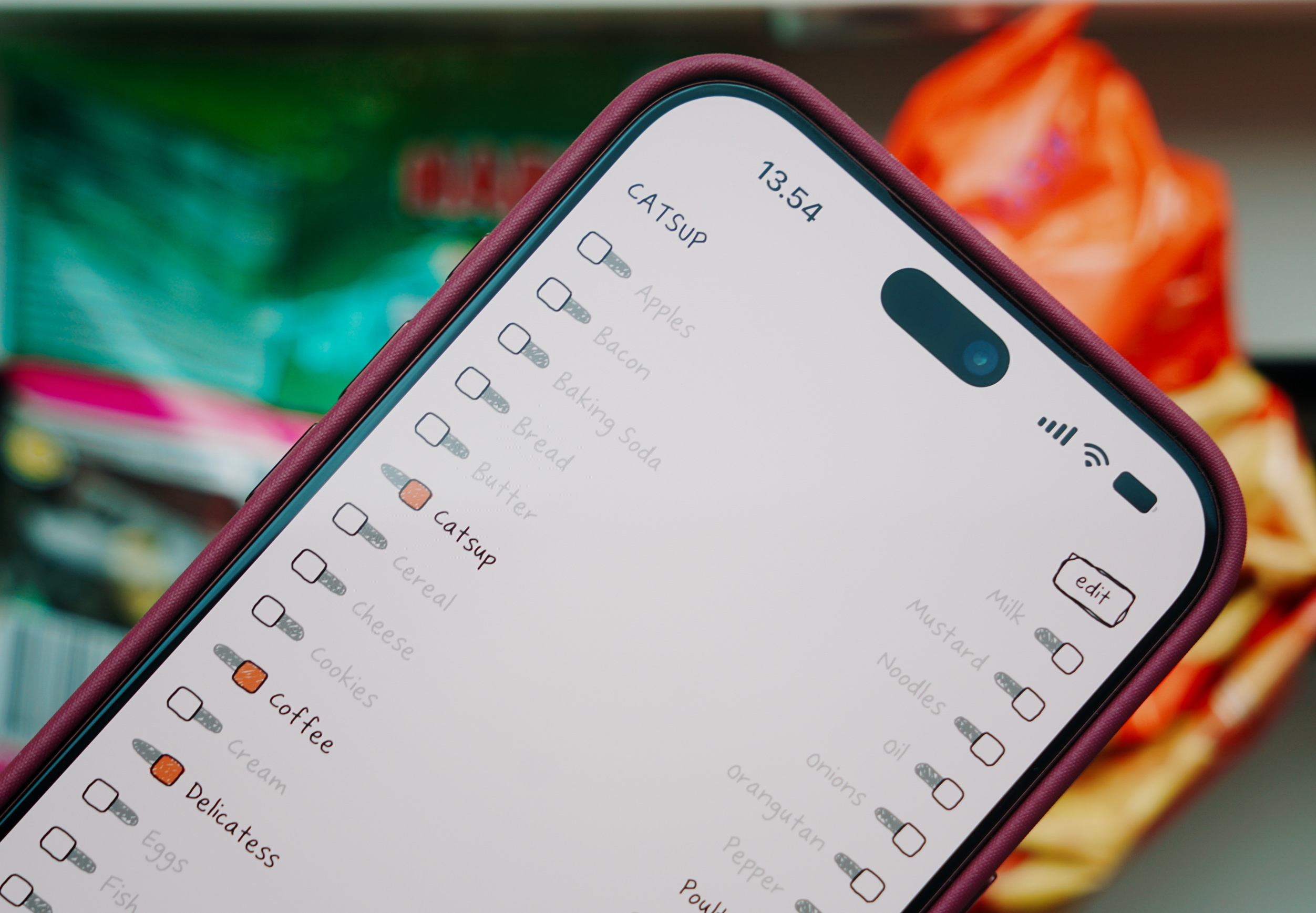 A smartphone screen displaying a grocery checklist application with items like catsup and apples.